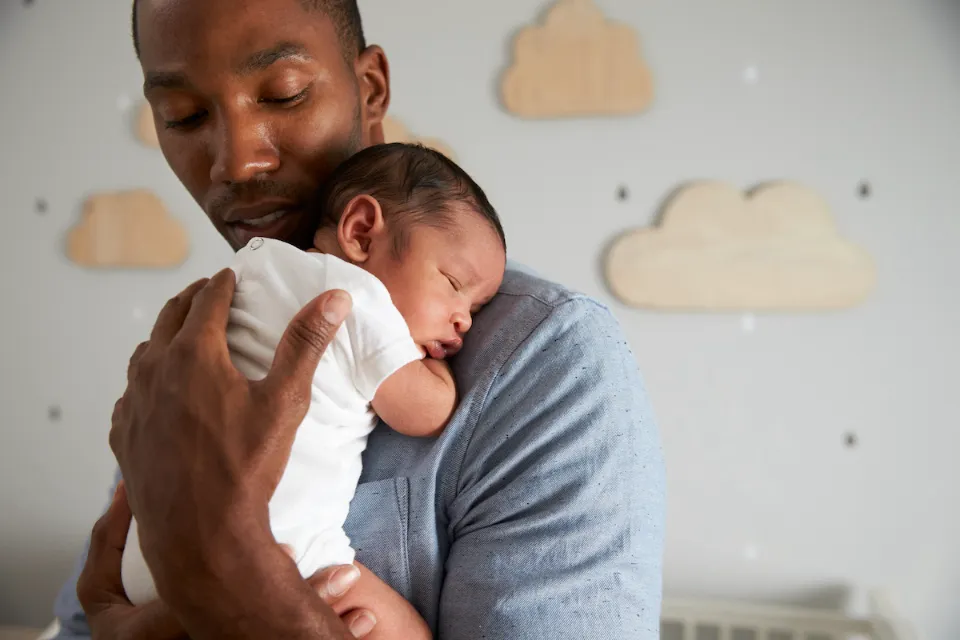 Dad with sleeping baby on shoulder.